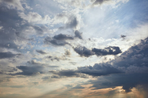 dark clouds and sun rays on blue sky background
