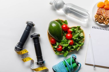 Beyaz arka planda taze diyet gıda ve su ile spor ekipmanları üst görünümü