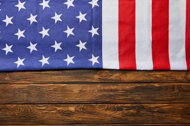 top view of usa flag on wooden brown background with copy space clipart