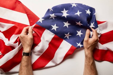 beyaz arka plan üzerinde buruşuk Amerikan bayrağı tutan adam kırpılmış görünümü 