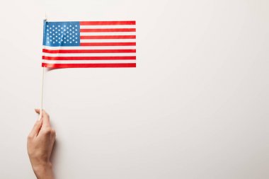 kopya alanı ile beyaz arka plan üzerinde Amerikan bayrağı tutan kadın kısmi görünümü