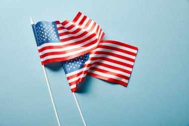 mavi arka plan üzerinde sopalar üzerinde Amerikan bayrakları üst görünümü