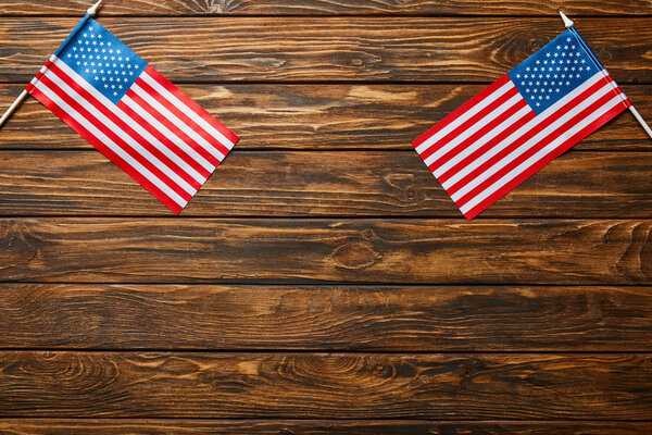 top view of american flags on wooden brown surface with copy space