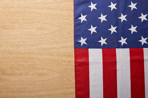 top view of national american flag on beige wooden surface with copy space