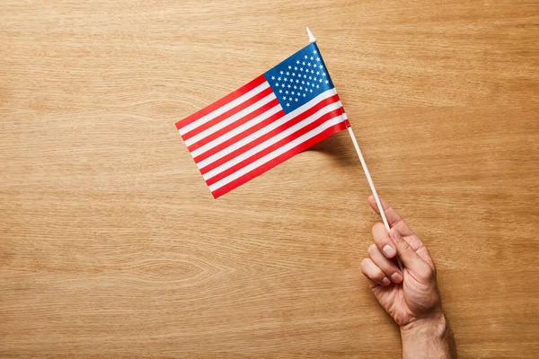 Vista Cortada Homem Segurando Bandeira Americana Fundo Madeira — Fotografia de Stock