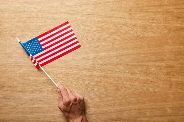 Vista Cortada Homem Segurando Bandeira Americana Fundo Madeira Com Espaço — Fotografia de Stock