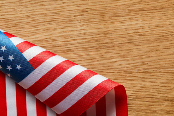 вид скрученного американского флага на деревянной поверхности с копировальным пространством
