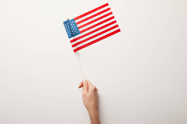 Вид сверху женщины, держащей американский флаг на белом фоне
 