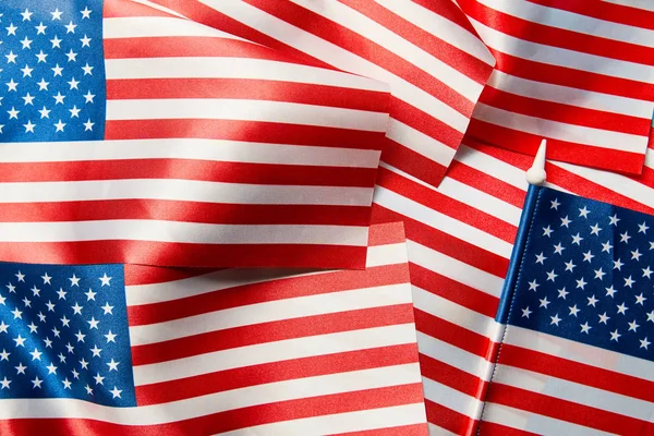 close up view of shiny satin american flags in pile