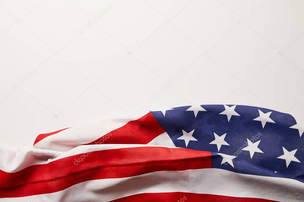 top view of crumpled american flag on white surface with copy space