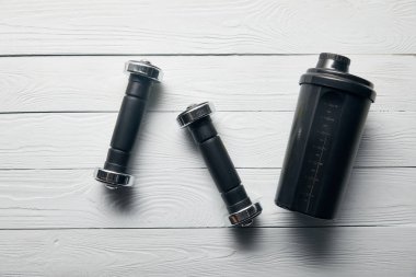 ahşap beyaz arka plan üzerinde siyah shaker fincan ve halter üst görünümü
