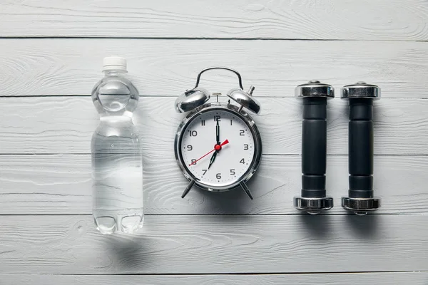 Flat Lay Silver Alarm Clock Bottle Water Dumbbells Wooden White — Stock Photo, Image