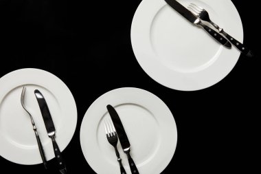 siyah üzerinde izole çatal ile beyaz yuvarlak plakalar üst görünümü