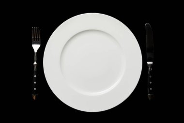 siyah üzerinde izole çatal ile beyaz boş yuvarlak plaka ve bıçak üst görünümü
