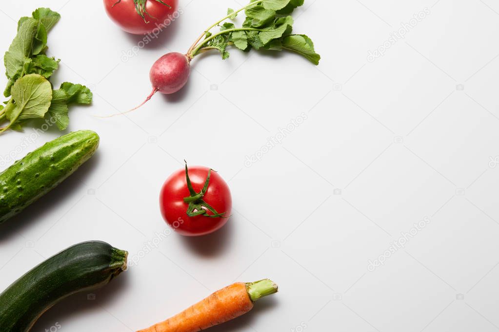 top view of raw fresh vegetables with green leaves on white background with copy space