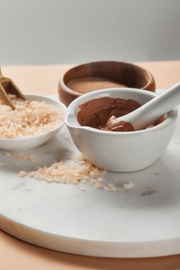 gri üzerine izole mermer yüzey üzerinde kaselerde kil ve deniz tuzu seçici odak