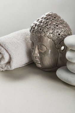 cotton towel, stones, Buddha figurine on white table isolated on grey clipart