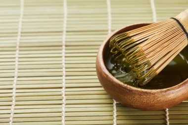kopya alanı ile masa mat üzerinde ahşap kase yeşil matcha tozu ve bambu çırpıcı