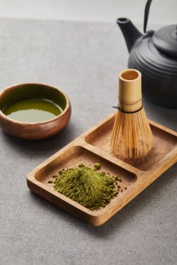 yeşil matcha tozu ve bambu çırpıcı seçici odak siyah çaydanlık ve çay ile kase yakın ahşap tahta üzerinde