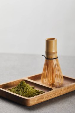 ahşap tahta üzerinde yeşil matcha tozu ve bambu çırpıcı