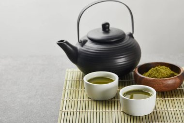 siyah çaydanlık ve bambu masa paspas çay ile bardak yakın ahşap kase yeşil matcha tozu seçici odak