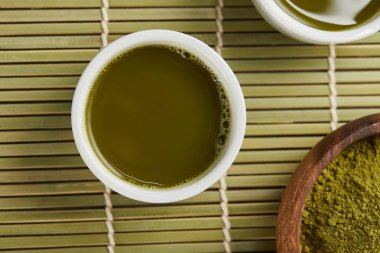 ahşap kase matcha tozu yakınında yeşil çay ile beyaz bardak üst görünümü