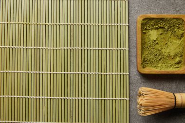 bambu çırpMa ve masa paspas yakınında ahşap tahta üzerinde yeşil matcha tozu üst görünümü