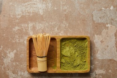 ahşap tahta üzerinde matcha tozu ve bambu çırpıcı üst görünümü