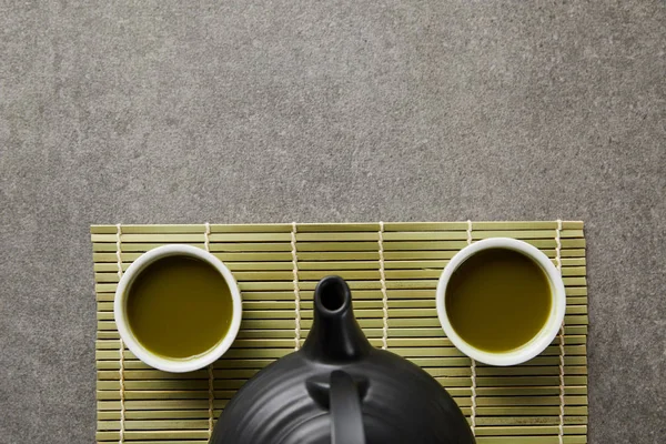 Вид Сверху Белые Чашки Маття Черный Чайник Зеленый Бамбуковый Коврик — стоковое фото
