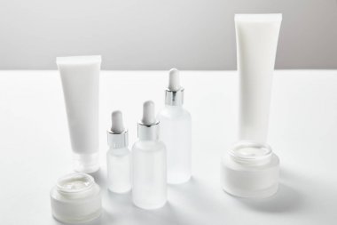 krem tüpler, kozmetik cam şişeler ve beyaz krem ile açık kavanoz 