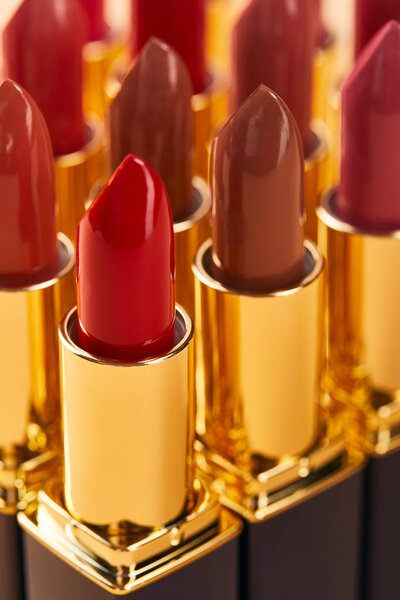 selective focus of various red shades of lipstick in tubes 