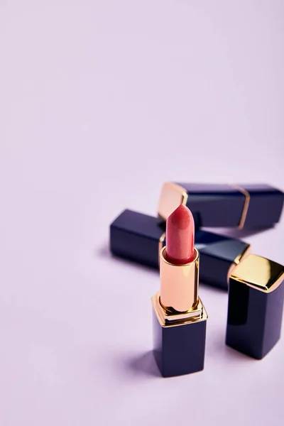Different Shiny Lipsticks Tubes Violet — Stock Photo, Image