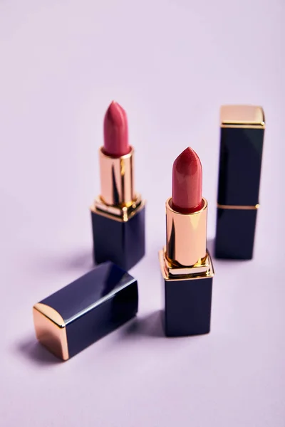 Verschiedene Rote Lippenstifte Röhrchen Auf Violett — Stockfoto