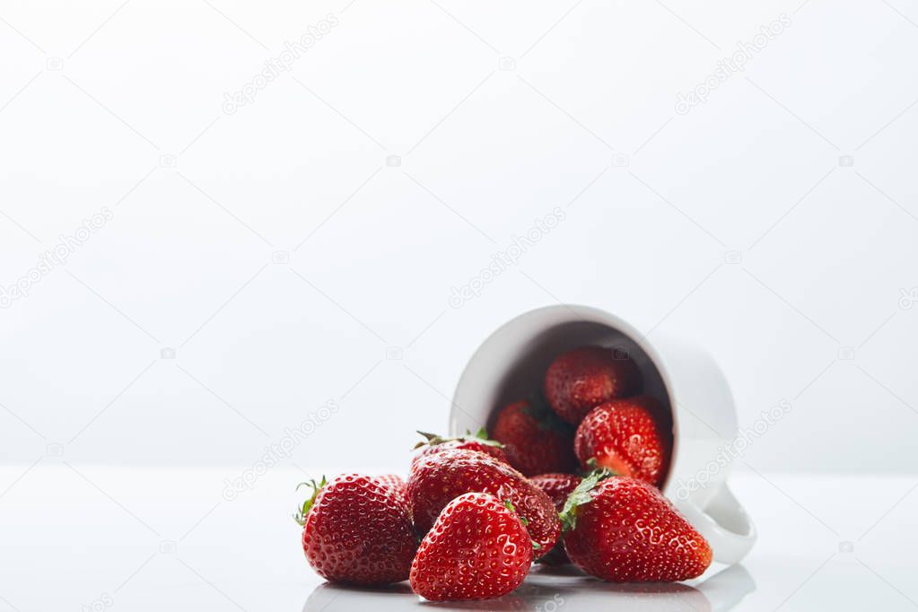 sweet organic strawberries in cup on white background
