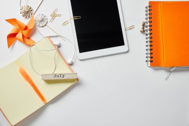 turuncu dizüstü bilgisayarlar, kırtasiye, dekorasyon nesneleri ve beyaz yüzeyüzerinde kulaklık yakın dijital tablet üst görünümü