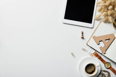 beyaz yüzeyde dijital tablet, kırtasiye, kahve, saat ve dizüstü bilgisayar üst görünümü