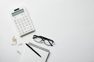 top view of stationery, calculator and notebook with pen on white surface clipart