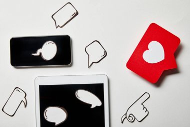 kağıt düşünce ve konuşma kabarcıkları, kağıt kalp, beyaz yüzey üzerinde işaret kartı ile dijital tablet ve akıllı telefon
