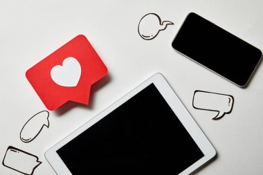 beyaz yüzeyde işaret kartı, kağıt düşünce ve konuşma kabarcıkları gibi dijital tablet yakın akıllı telefon