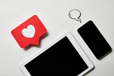 beyaz yüzeyüzerinde işaret kartı ve kağıt konuşma balonu gibi dijital tablet yakın akıllı telefon