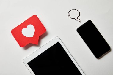 beyaz yüzeyüzerinde işaret kartı ve kağıt konuşma balonu gibi dijital tablet yakın akıllı telefon