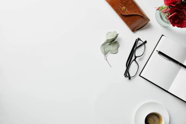 Beyaz Yüzeyüzerinde Defteri Kalem Gözlük Kasa Bitki Kahve Üst Görünümü — Stok fotoğraf