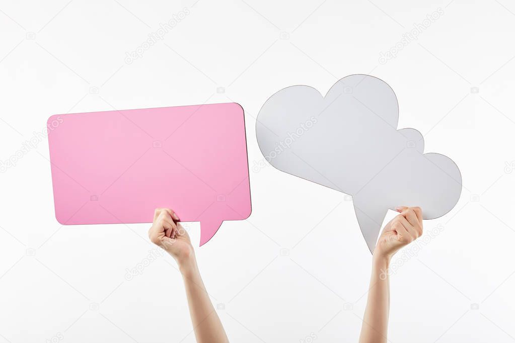 cropped view of woman with pink thought and speech bubbles in hands isolated on white