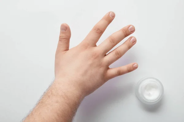 Przycięte Widok Człowieka Trzyma Rękę Białej Powierzchni Kosmetyk Krem Słoiku — Zdjęcie stockowe