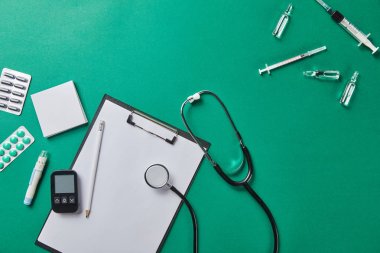 yeşil yüzeyüzerinde klasör ve stetoskop yakın çeşitli tıbbi malzemelerin üst görünümü 