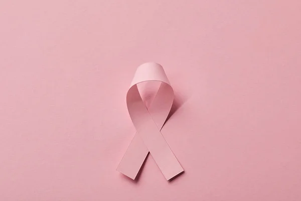 ピンクの背景に乳癌リボンのトップビュー — ストック写真