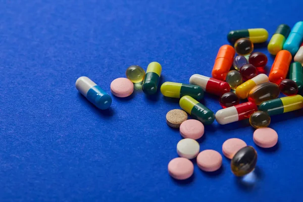 Verschillende Kleurrijke Verspreide Medische Pillen Blauwe Achtergrond — Stockfoto