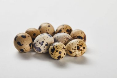 few small quail eggs on white surface clipart