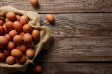  top view of chicken eggs at cloth on wooden table clipart