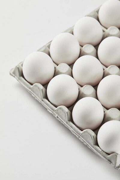 chicken eggs in carton box on white surface